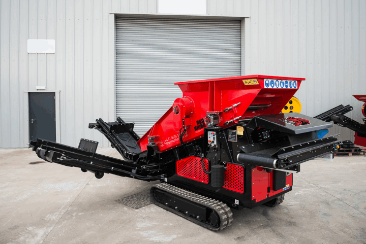 Powerful Red Rhino 3-way mobile screener on tracks, ideal for efficient material separation on construction and demolition sites.