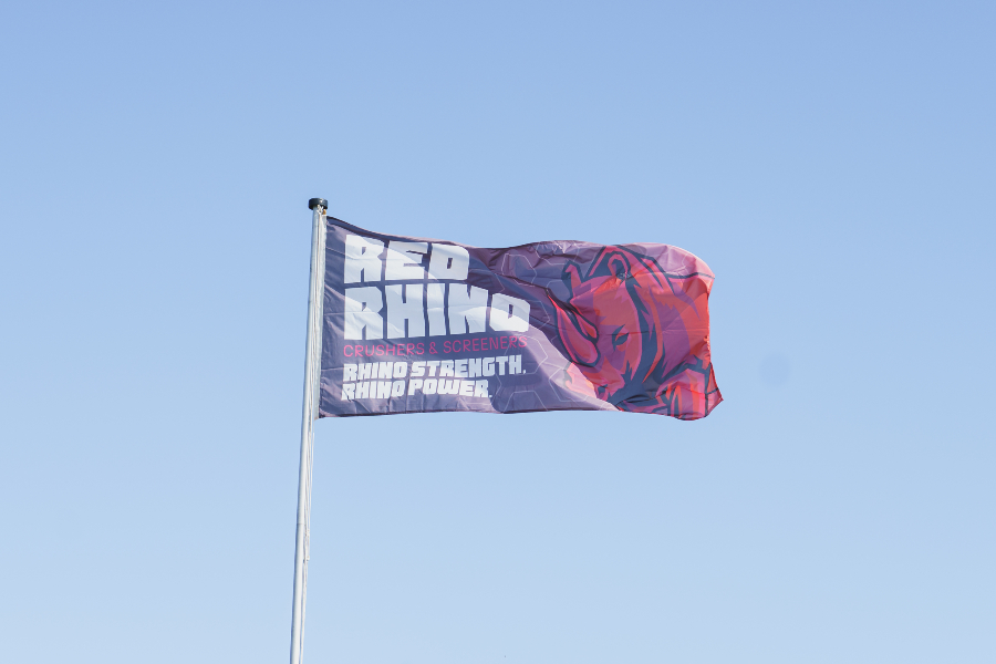 Red Rhino flag against a bright blue sky in the background