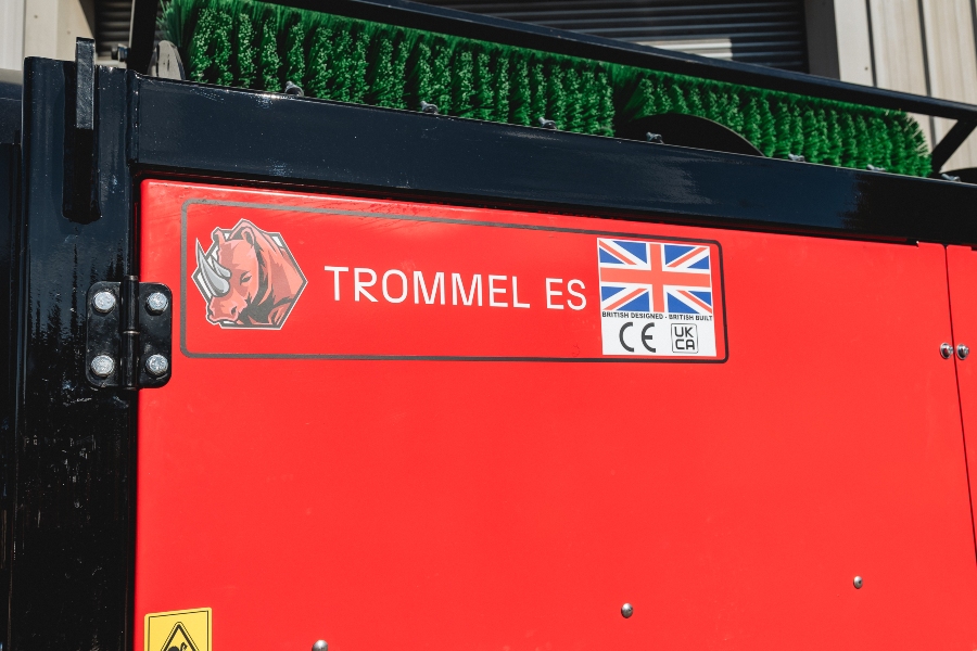 Close-up of the Red Rhino Electric Trommel's bright red panel, showing the 'TROMMEL ES' logo with a rhino head, and a sticker indicating 'BRITISH DESIGNED - BRITISH BUILT' along with UK and CE conformity marks